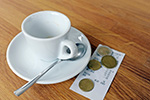 Kaffeetasse mit Rechnung und Münzen