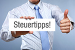 Hand mit Schild mit Aufschrift Steuertipps